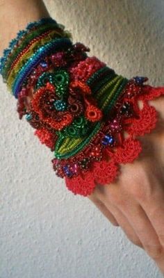 a woman's hand is adorned with colorful bracelets