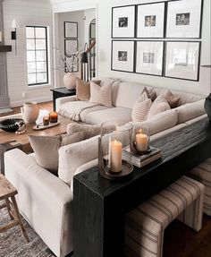 a living room filled with furniture and candles on top of a coffee table in front of a fire place