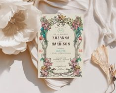 the wedding card is surrounded by flowers and leaves