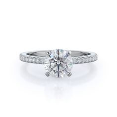 a diamond engagement ring with channel set diamonds on the band and side stones in white gold