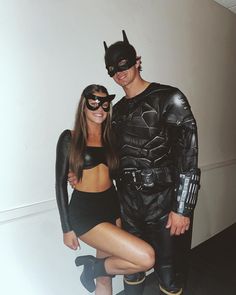 a man and woman dressed up as batman and catwoman pose for a photo together