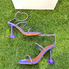 Made In Italy, Amina Muaddi's Gilda Sandals Boast A Translucent Flared Heel. This High-Heel Style Is Adorned With Tonal Crystals Atop Pvc Straps. Pvc Upper Open Toe Adjustable Buckle Closure Leather/Tpu Sole Made In Italy Heel Height, 3.75" (95mm) Designer Purple Heels For Party, Embellished Purple Heels For Evening, Purple High Heel Shoes For Events, Summer Purple Rhinestone Heels, Purple Embellished Open Toe Heels, Embellished Purple High Heels, Purple Embellished High Heels, Lilac Shoes, Amina Muaddi Shoes