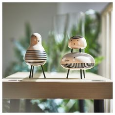 two small wooden birds sitting on top of a table