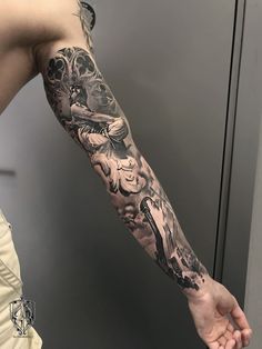 a man with a tattoo on his arm holding onto the arm of another person's hand