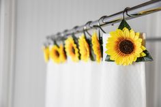 the sunflowers are hanging on the curtain rod