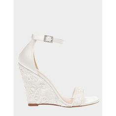 a white wedged sandal with an open toe and lace detailing on the heel