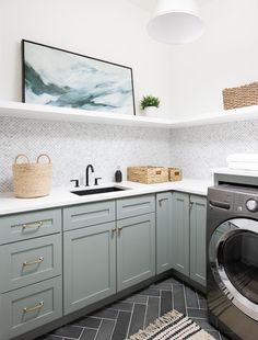 a washer and dryer sitting in a kitchen next to each other on top of cabinets