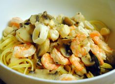 a white bowl filled with pasta and shrimp