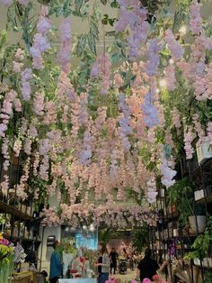 purple flowers hanging from the ceiling in a flower shop