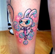 a cartoon character tattoo on the leg of a woman's leg, with stars and bubbles