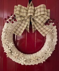 a christmas wreath hanging on a red door