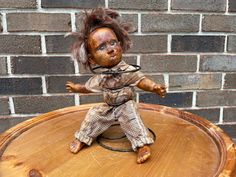 a doll sitting on top of a wooden table