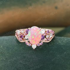 an opalite and diamond ring on top of a wooden table