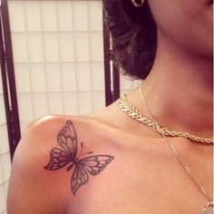 a woman's chest with a butterfly tattoo on the left side of her shoulder