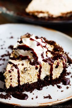 a piece of cheesecake with chocolate sauce and whipped cream