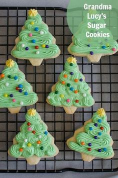 cookies decorated with green frosting and christmas trees are on a cooling rack in front of the words grandma lucy's sugar cookies