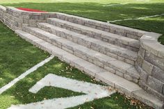 a stone wall and steps in the grass