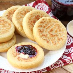 several pancakes on a plate with jam and butter