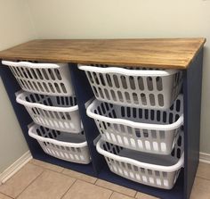 three laundry baskets stacked on top of each other in front of a wooden countertop