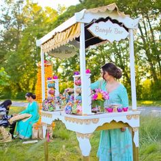 a woman standing in front of a table filled with cupcakes and candy bars