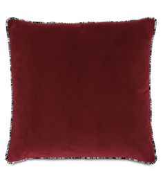 a red velvet pillow with fringe trim