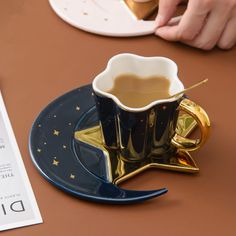 a coffee cup sitting on top of a saucer next to a piece of paper