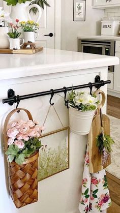 a kitchen island with flowers hanging from it's hooks