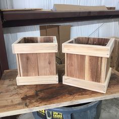 two wooden planters sitting on top of a table in a room with other boxes