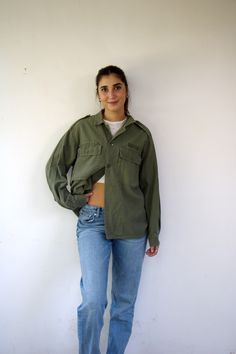 This awesome vintage green military shirt/jacket is nicely broken in, and features a button-up design with pockets. Made from cotton, it includes ventilation openings under the arms. Unisex and suitable for both men and women, aside from minor signs of wear, good vintage condition, clean ready to wear, this piece is a versatile and stylish addition to any wardrobe. ** Model is 5'7" and size S for reference **      Approximate size:  M/L- please refer to the measurements. M E A S U R E M E N T S -were taken with garments laying flat, please double where necessary. ------------------------♥-------- Length:  27"-69cm Armpit to Armpit: 23"-59cm (closed) Shoulder to Shoulder: 19.5" - 50cm Sleeve: 22.5"- 57cm. ---------------------------------------------- All items are vintage pieces, previousl Vintage Relaxed Fit Button-up Shacket, Fall Utility Khaki Shirt, Green Cotton Button-up Utility Jacket, Green Military Style Button-up Shirt, Retro Green Utility Jacket For Fall, Military Style Shirt With Pockets For Fall, Green Collared Utility Jacket With Button Closure, Military Style Collared Shirt For Fall, Fall Military Collared Shirt