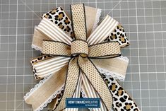 a bow made out of fabric with leopard print and ribbon around it on a cutting board