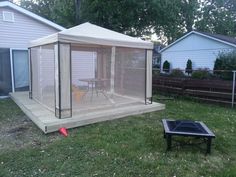 a backyard area with a gazebo, table and chairs