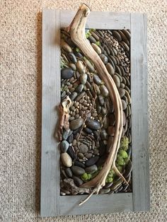 a piece of art made out of rocks and driftwood is displayed on the floor