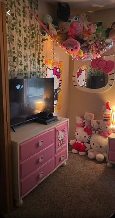 a bedroom with hello kitty decorations on the ceiling and pink dressers in front of it