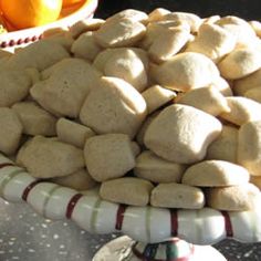 a bowl filled with marshmallows sitting on top of a table next to an orange