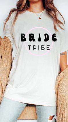 a woman wearing a white t - shirt with the word bride tribe printed on it