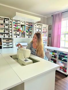 a woman is sitting at a sewing machine