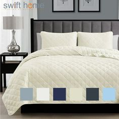 a bed with white and blue comforters in a bedroom next to two pictures on the wall