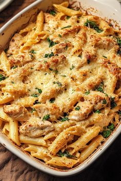 a casserole dish filled with chicken, pasta and parmesan cheese sauce