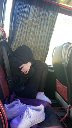 a person sitting in the back of a car with their head on his handbag