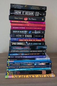 a stack of books sitting on top of a wooden table