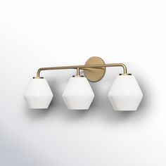 three light brass bathroom fixture with white glass shades on an off - white wall background