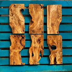 four pieces of wood sitting on top of a blue wall