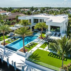 an aerial view of a house with a swimming pool and palm trees in the foreground