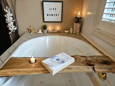 a bath tub with candles and pictures on the wall