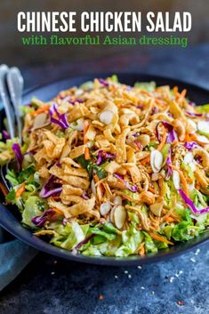 a salad with chicken, carrots, and lettuce in a black bowl