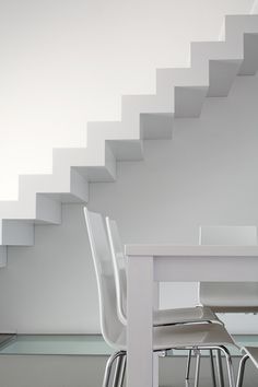 a white table and chairs under a stair case