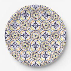 an orange and blue patterned plate with circular designs on it, against a white background