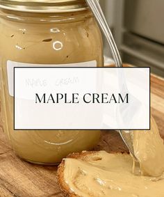 a jar of maple cream sitting on top of a wooden cutting board next to a slice of bread