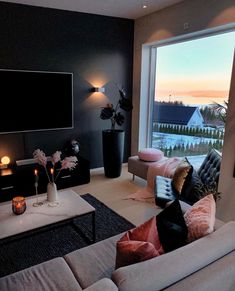 a living room filled with furniture and a flat screen tv mounted to the side of a wall