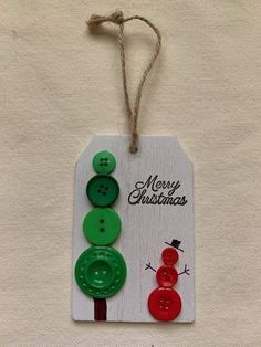 a christmas tag with three buttons attached to it